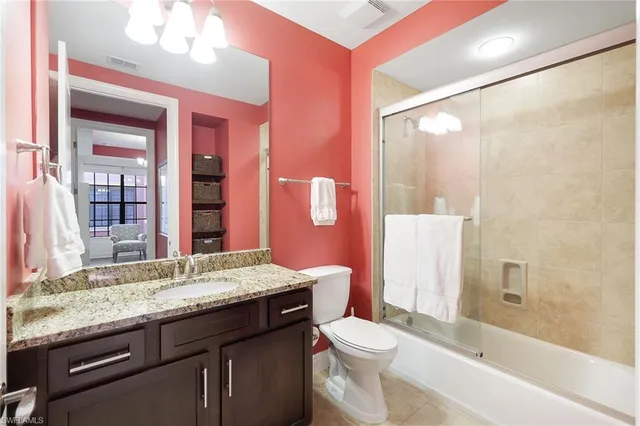 a bathroom with a granite countertop sink toilet and shower