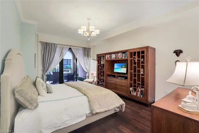 a bedroom with a bed and a flat tv screen on dresser