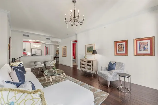 a living room with furniture a chandelier and a wooden floor