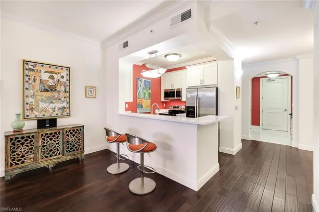 a kitchen with stainless steel appliances kitchen island granite countertop a sink cabinets and wooden floor