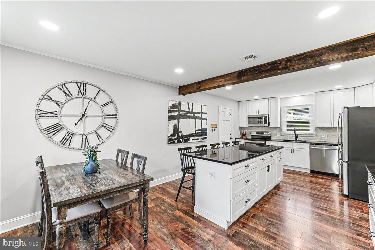 772 Hunters Run Road Pottstown, PA 19465 - Photo 15 of 44 a kitchen with stainless steel appliances kitchen island granite countertop a table chairs a stove a sink and a refrigerator