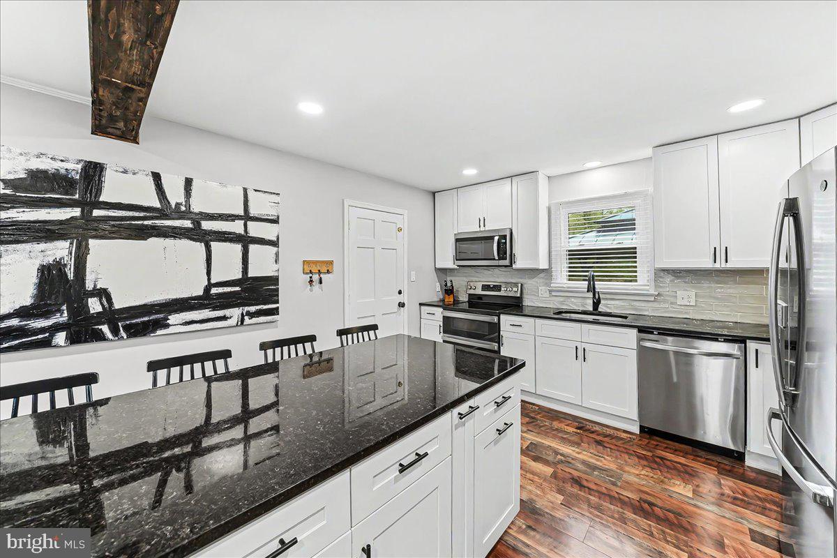 772 Hunters Run Road Pottstown, PA 19465 - Photo 18 of 44 a kitchen with stainless steel appliances granite countertop a stove top oven a sink dishwasher and a refrigerator with wooden floor
