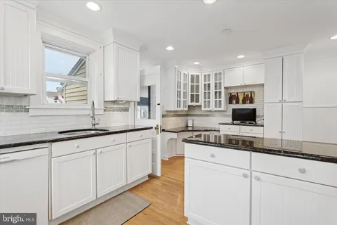 a kitchen with granite countertop white cabinets and white appliances