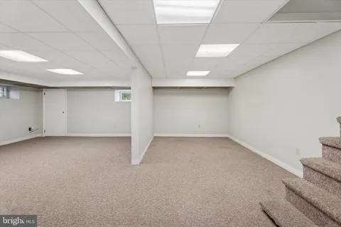 an empty room with staircase and white walls