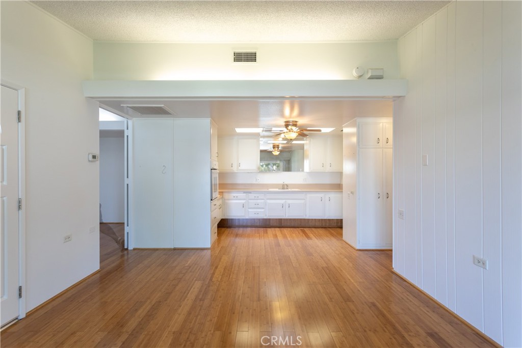 1180 Oakmont Road, Unit 51H Seal Beach, CA 90740 - Photo 19 of 31 a view of a kitchen from a hallway with wooden floor