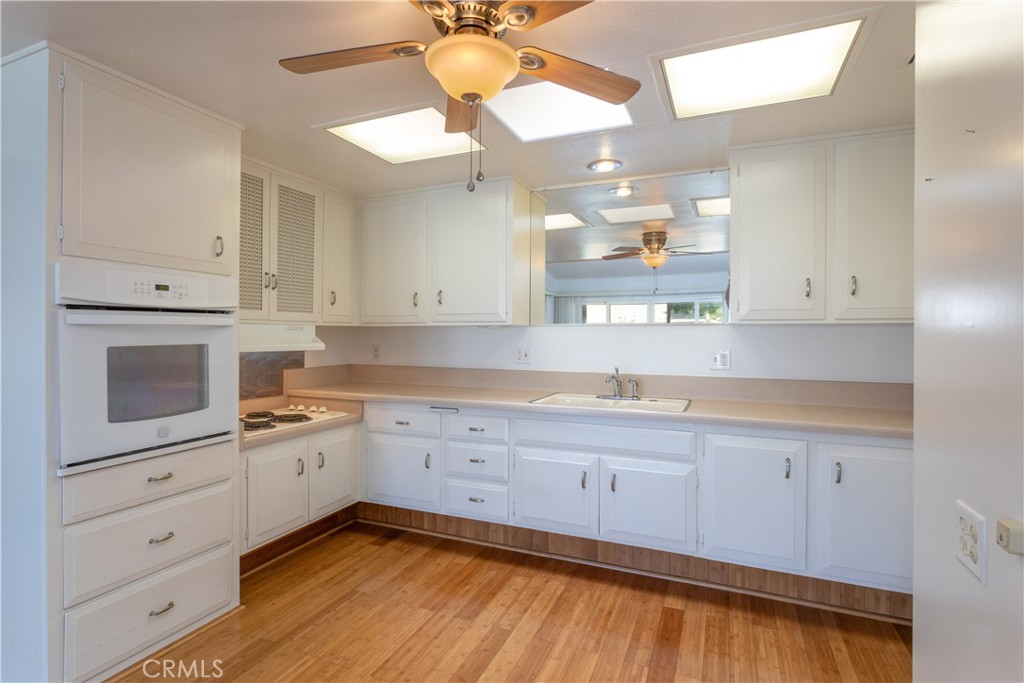 1180 Oakmont Road, Unit 51H Seal Beach, CA 90740 - Photo 20 of 31 a kitchen with white cabinets and sink
