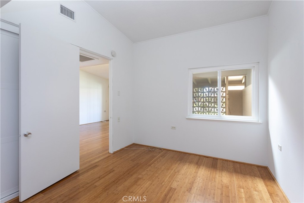 1180 Oakmont Road, Unit 51H Seal Beach, CA 90740 - Photo 24 of 31 an empty room with wooden floor and windows