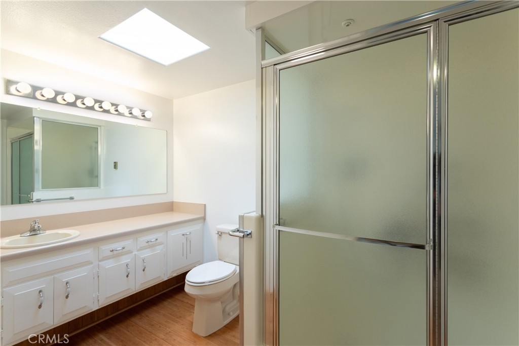 1180 Oakmont Road, Unit 51H Seal Beach, CA 90740 - Photo 27 of 31 a bathroom with a granite countertop sink toilet and shower