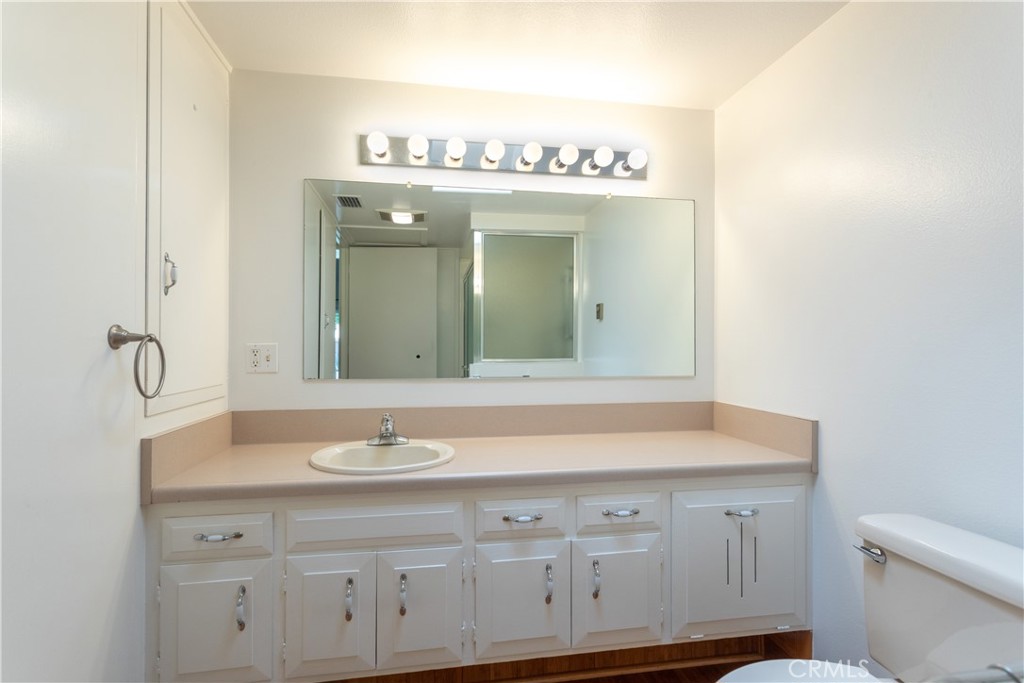 1180 Oakmont Road, Unit 51H Seal Beach, CA 90740 - Photo 28 of 31 a bathroom with a sink mirror and toilet