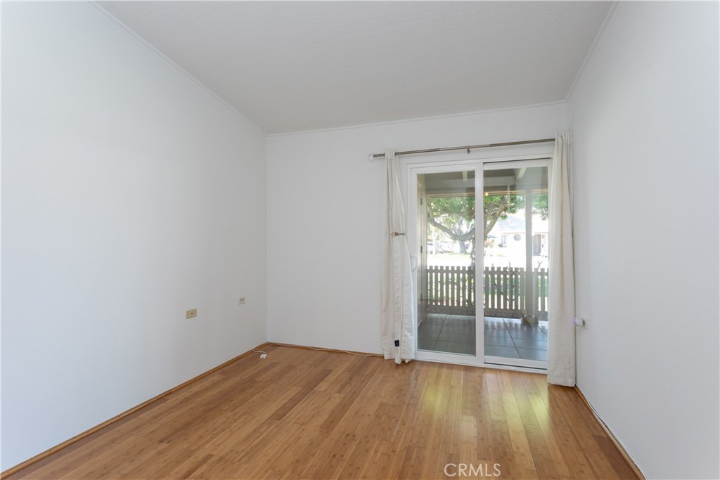 1180 Oakmont Road, Unit 51H Seal Beach, CA 90740 - Photo 29 of 31 an empty room with wooden floor and windows