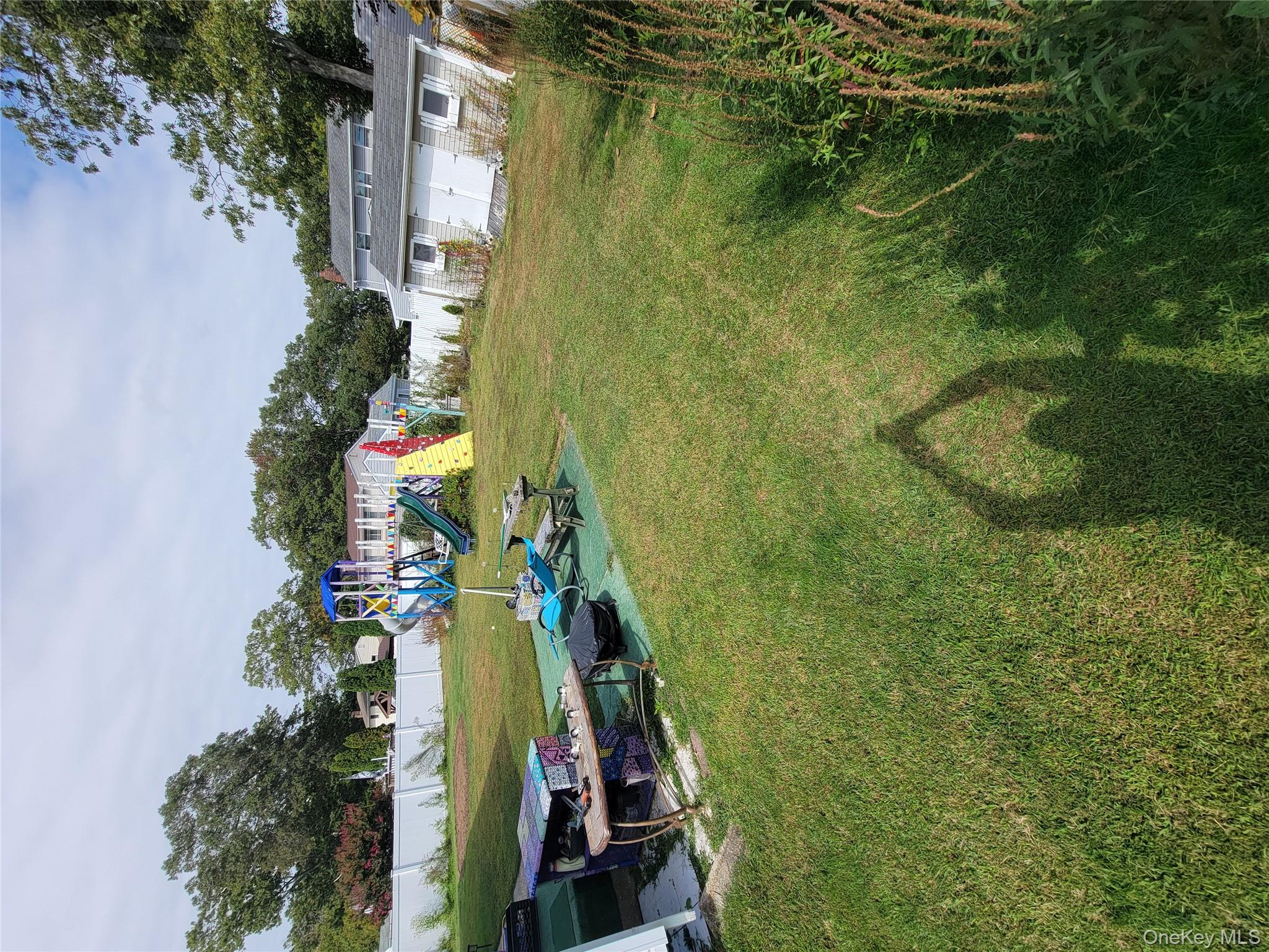 7 Deville Drive Selden, NY 11784 - Photo 19 of 19 a view of a lake with lawn chairs and large trees