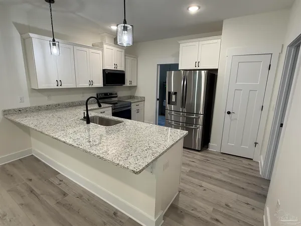 a kitchen with stainless steel appliances granite countertop a sink refrigerator and microwave