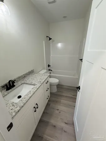 a bathroom with a granite countertop sink and a toilet