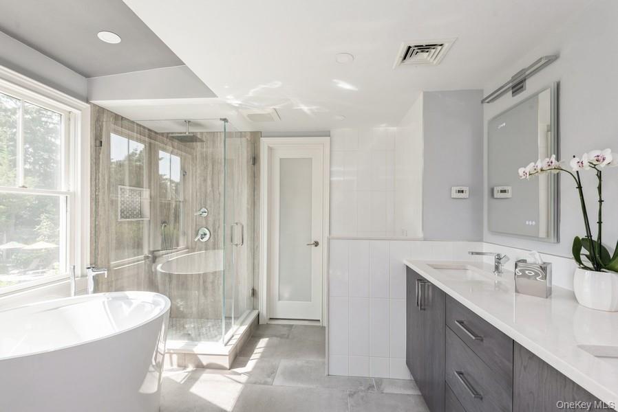 330 Private Road East Patchogue, NY 11772 - Photo 30 of 42 a spacious bathroom with a double vanity sink large mirror and a bathtub