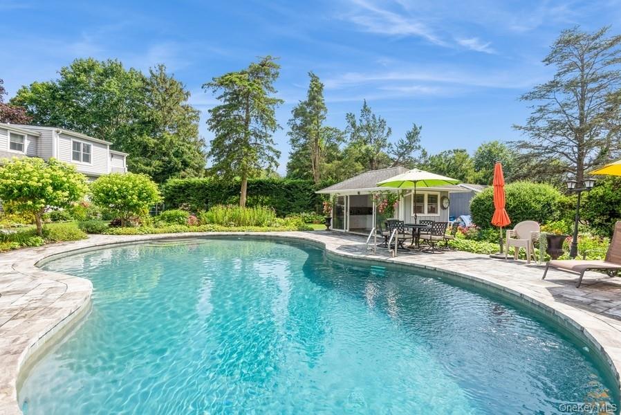 330 Private Road East Patchogue, NY 11772 - Photo 8 of 42 a view of a swimming pool with lawn chairs under an umbrella