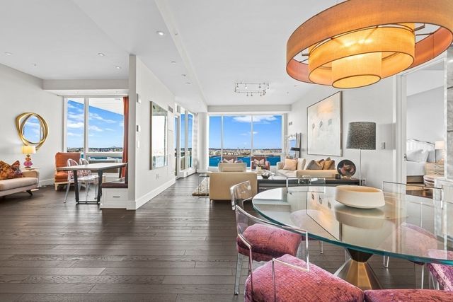 a dining hall with stainless steel appliances granite countertop a stove and a dining table with wooden floor