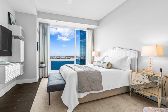 a bedroom with a large bed and a chandelier