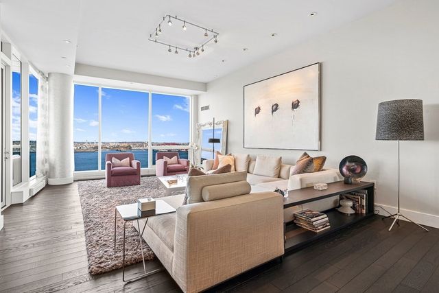 a living room with furniture kitchen view and a large window