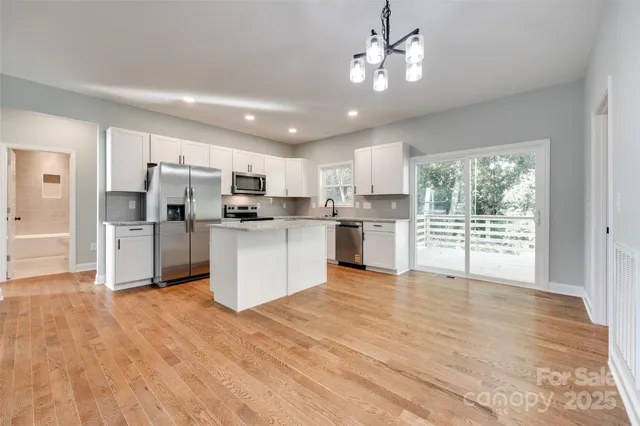 a kitchen with white cabinets and stainless steel appliances