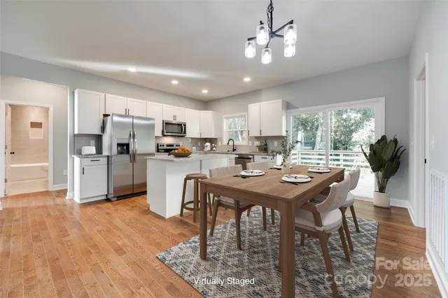 a kitchen with a table chairs refrigerator and microwave