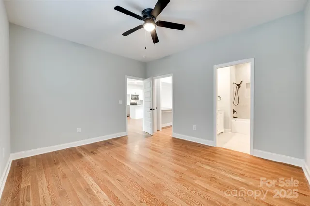a view of an empty room and window and wooden floor