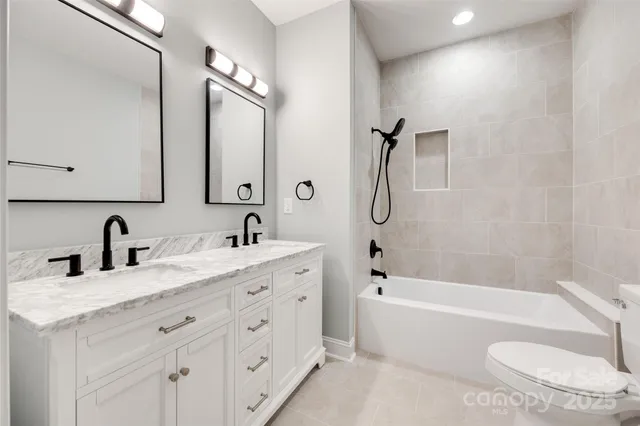 a bathroom with a granite countertop sink a toilet and bathtub