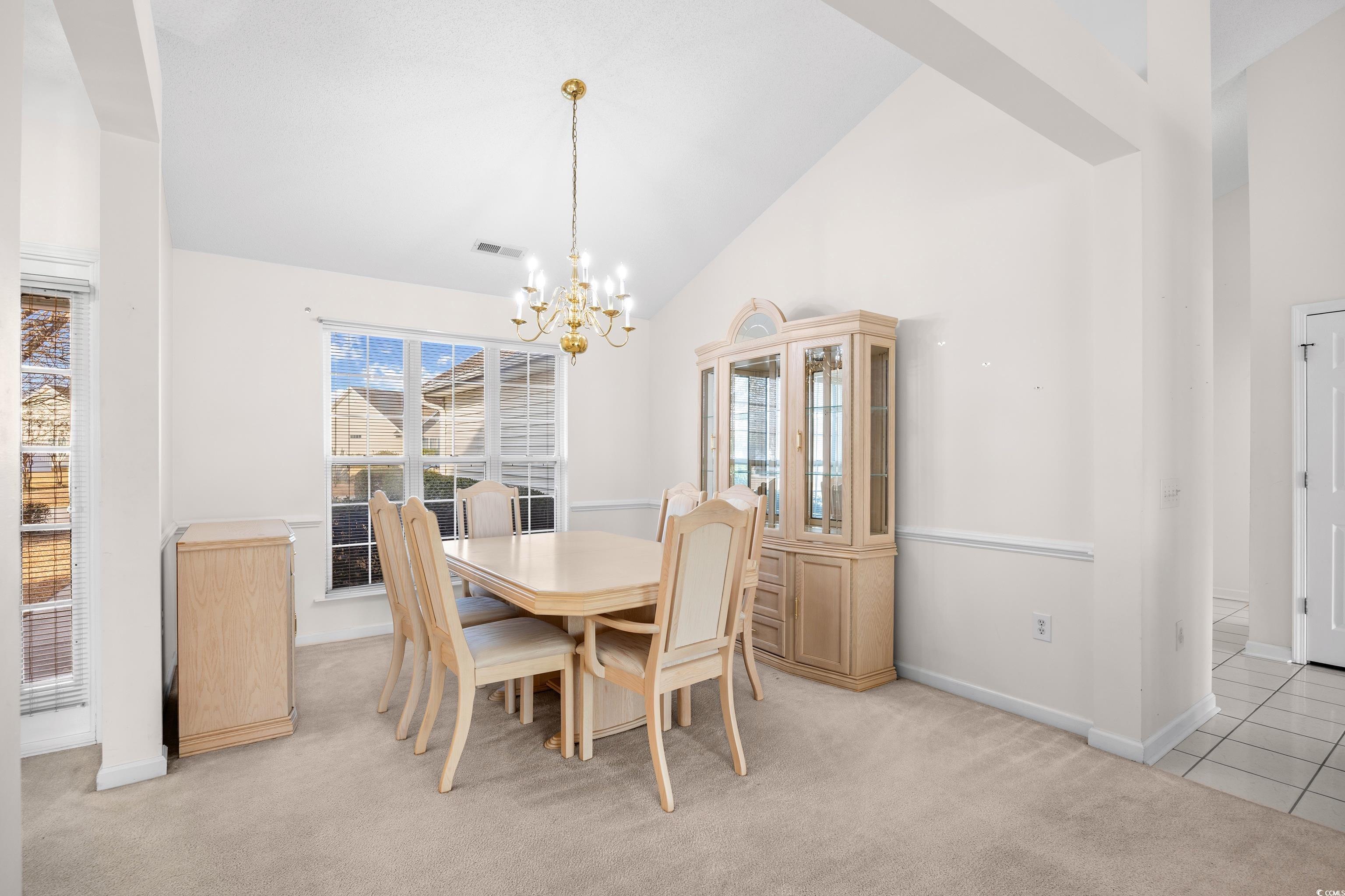 1744 Starbridge Drive Surfside Beach, SC 29575 - Photo 9 of 38 Dining area featuring high vaulted ceiling, light colored carpet, and a chandelier