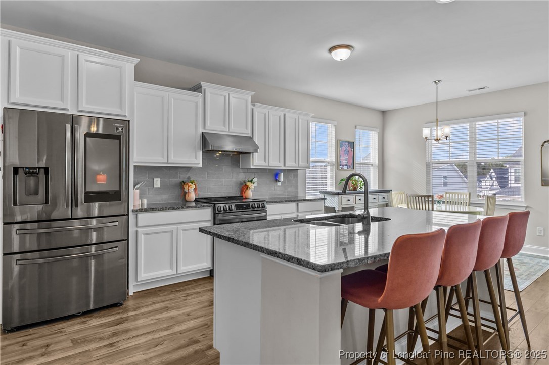 172 Haynes Church Road Raeford, NC 28376 - Photo 9 of 39 a kitchen with stainless steel appliances granite countertop a refrigerator a sink dishwasher a stove and white countertops with wooden floor