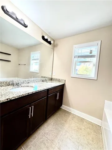 a bathroom with a granite countertop sink vanity and a mirror