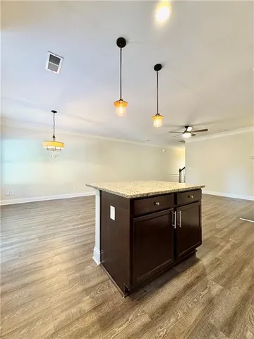 a kitchen with stainless steel appliances granite countertop a sink a stove and a wooden floor