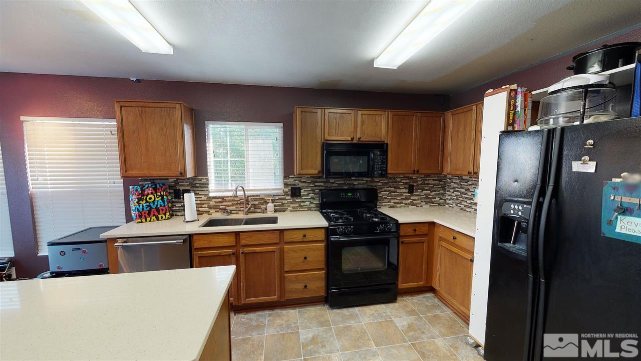 8900 Griffon Court Reno, NV 89506 - Photo 18 of 29 a kitchen with stainless steel appliances a stove a sink a microwave a refrigerator and cabinets