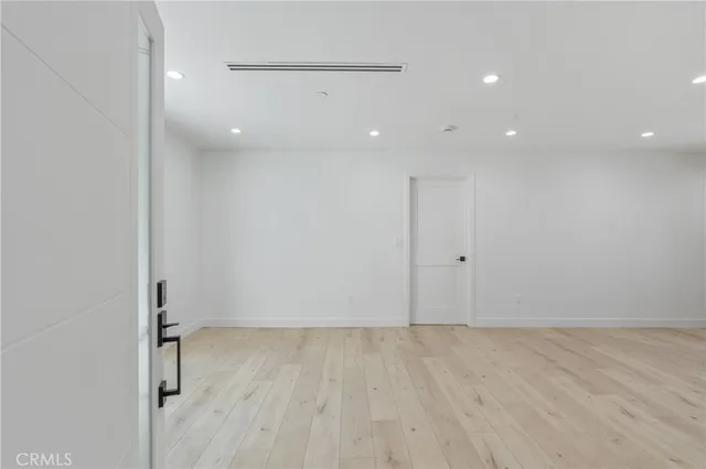 an empty room with wooden floor and a ceiling fan