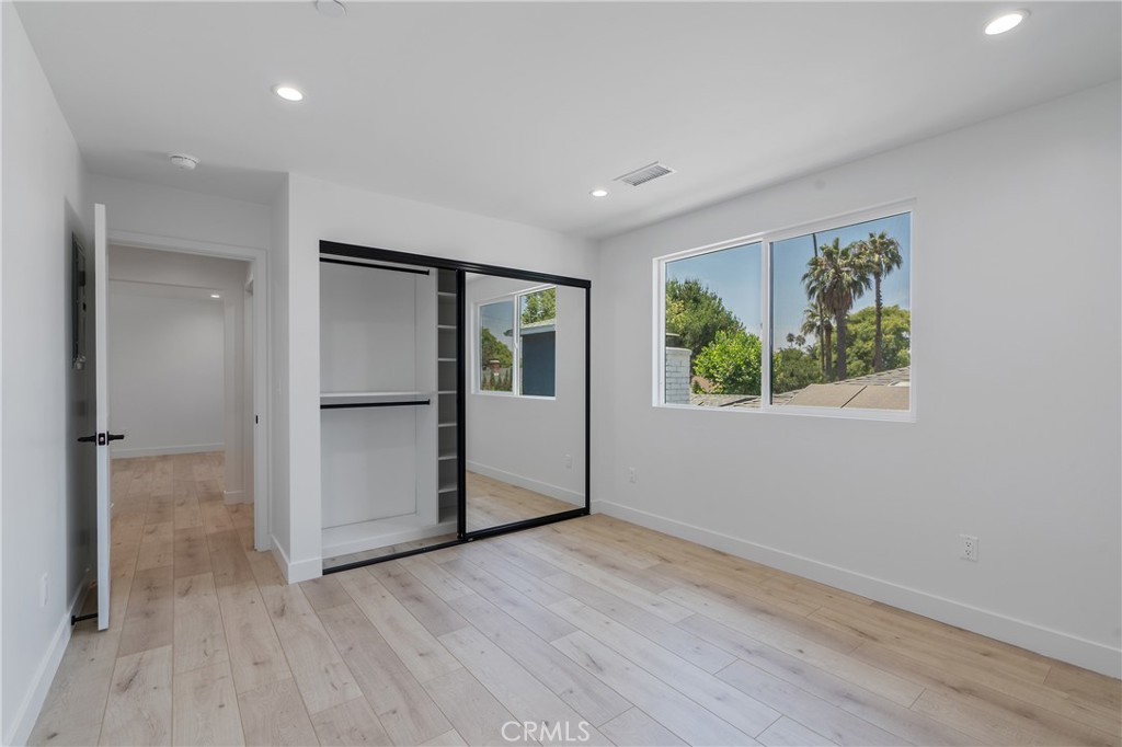 7435 Ranchito Avenue Van Nuys, CA 91405 - Photo 14 of 16 wooden floor in an empty room with a window