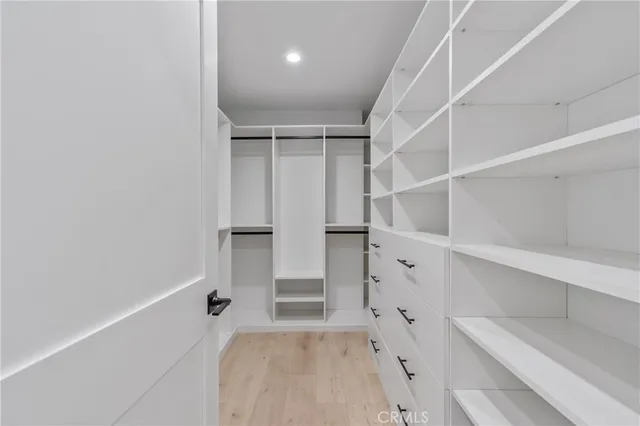 a view of walk in closet with empty racks