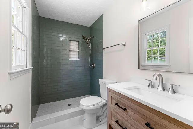 a bathroom with a sink a toilet and shower