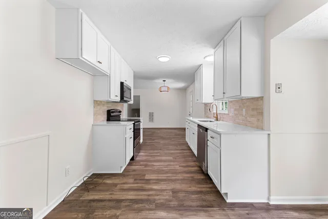 a kitchen with kitchen island granite countertop a sink and steel appliances