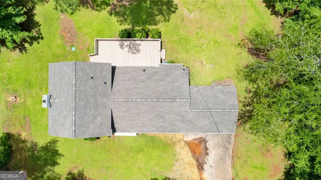 a view of a wall with potted plants and large tree