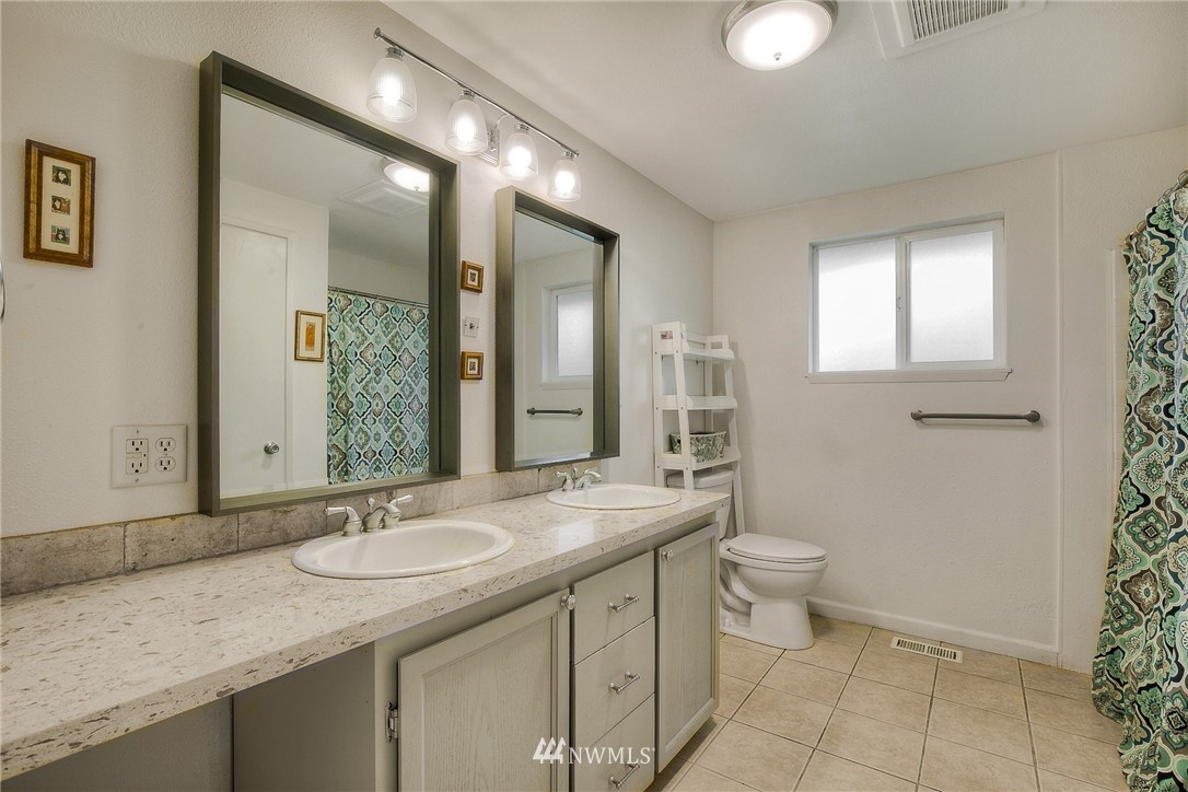 7484 Riverside Drive East Sumner, WA 98390 - Photo 13 of 23 a bathroom with a granite countertop sink toilet and mirror