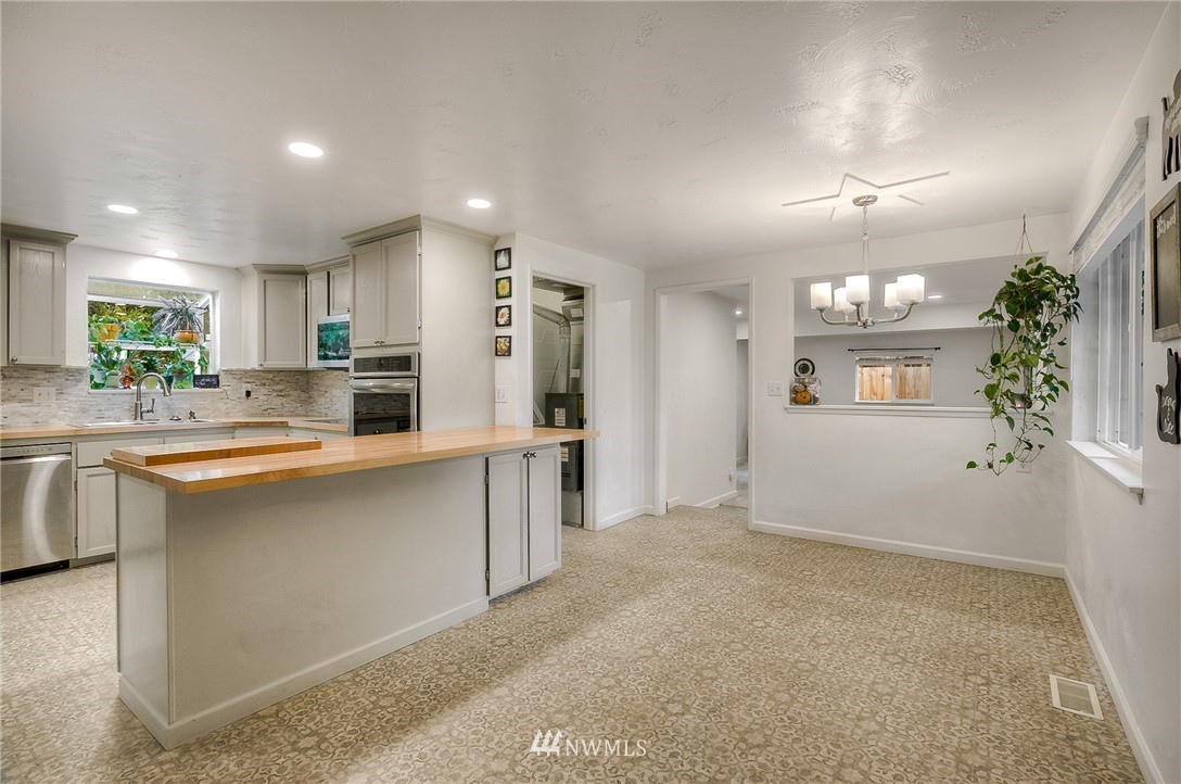 7484 Riverside Drive East Sumner, WA 98390 - Photo 5 of 23 a large kitchen with kitchen island a sink stainless steel appliances and cabinets