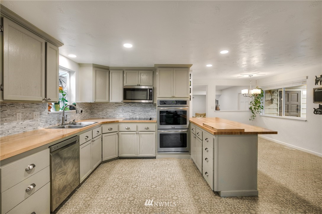 7484 Riverside Drive East Sumner, WA 98390 - Photo 6 of 23 a kitchen with stainless steel appliances granite countertop a sink and dishwasher a stove top oven with wooden floor