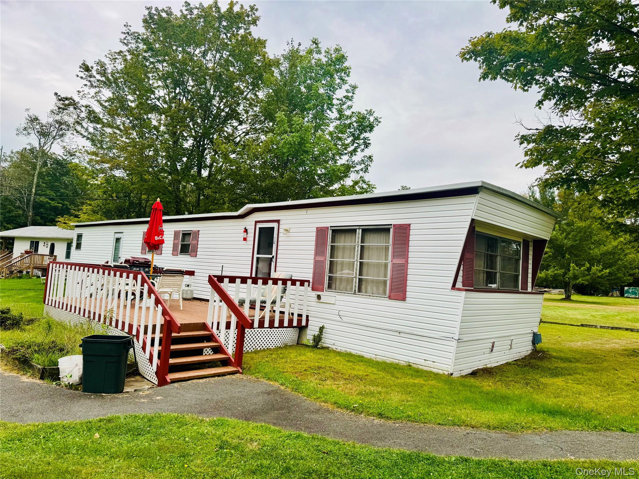 Manufactured / mobile home with a front yard and a deck