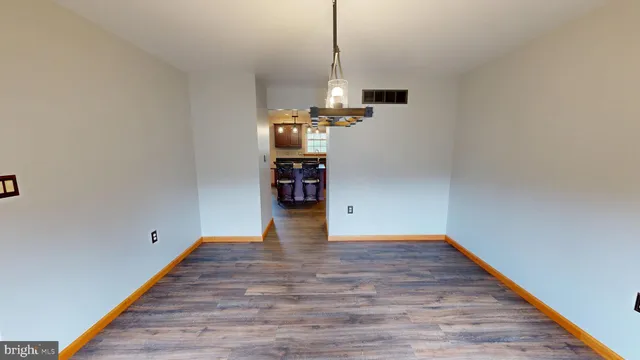 a kitchen with stainless steel appliances a dining table chairs and refrigerator