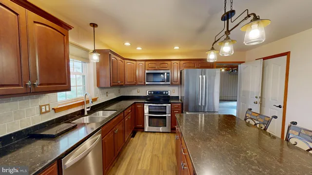 an empty room with wooden floor fireplace and windows