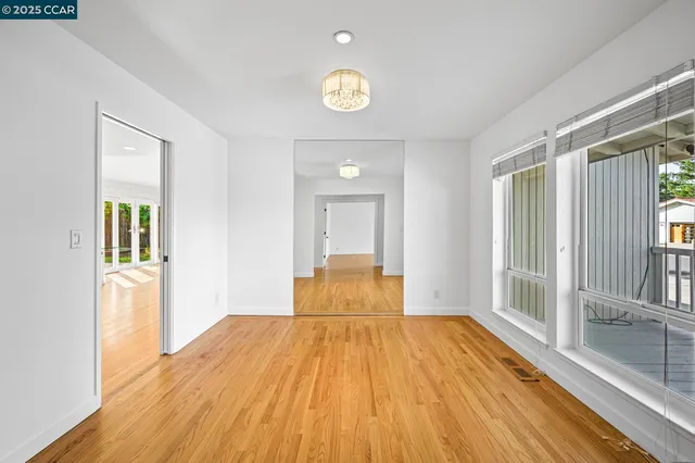 a view of empty room with window and wooden floor