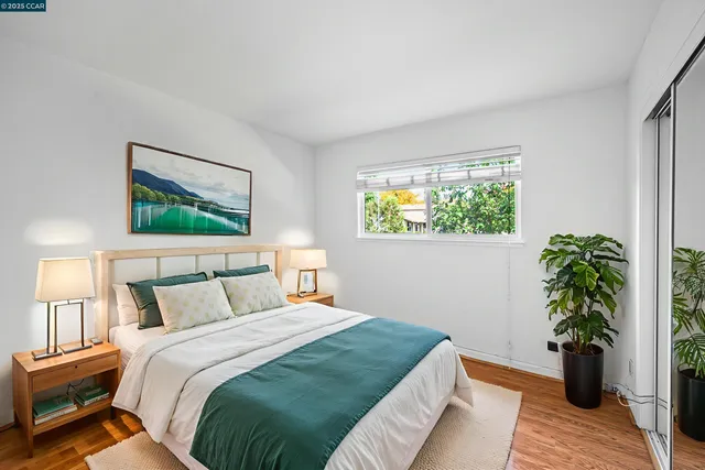 a view of an empty room with wooden floor and closet