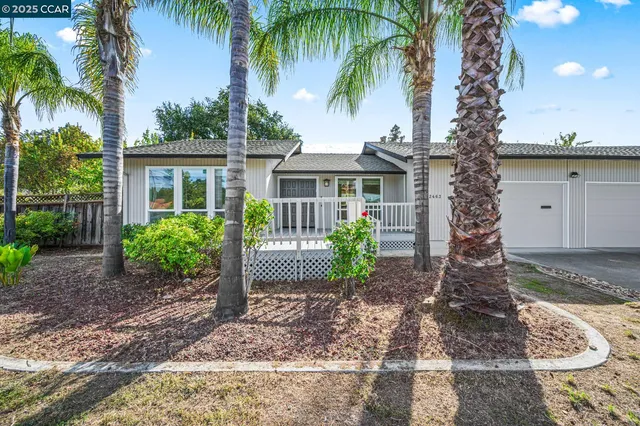 a view of a white house with a yard and potted plants