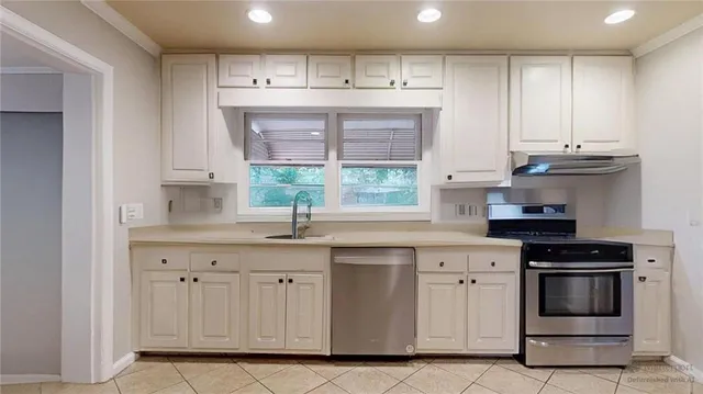 a kitchen that has a sink a refrigerator and window