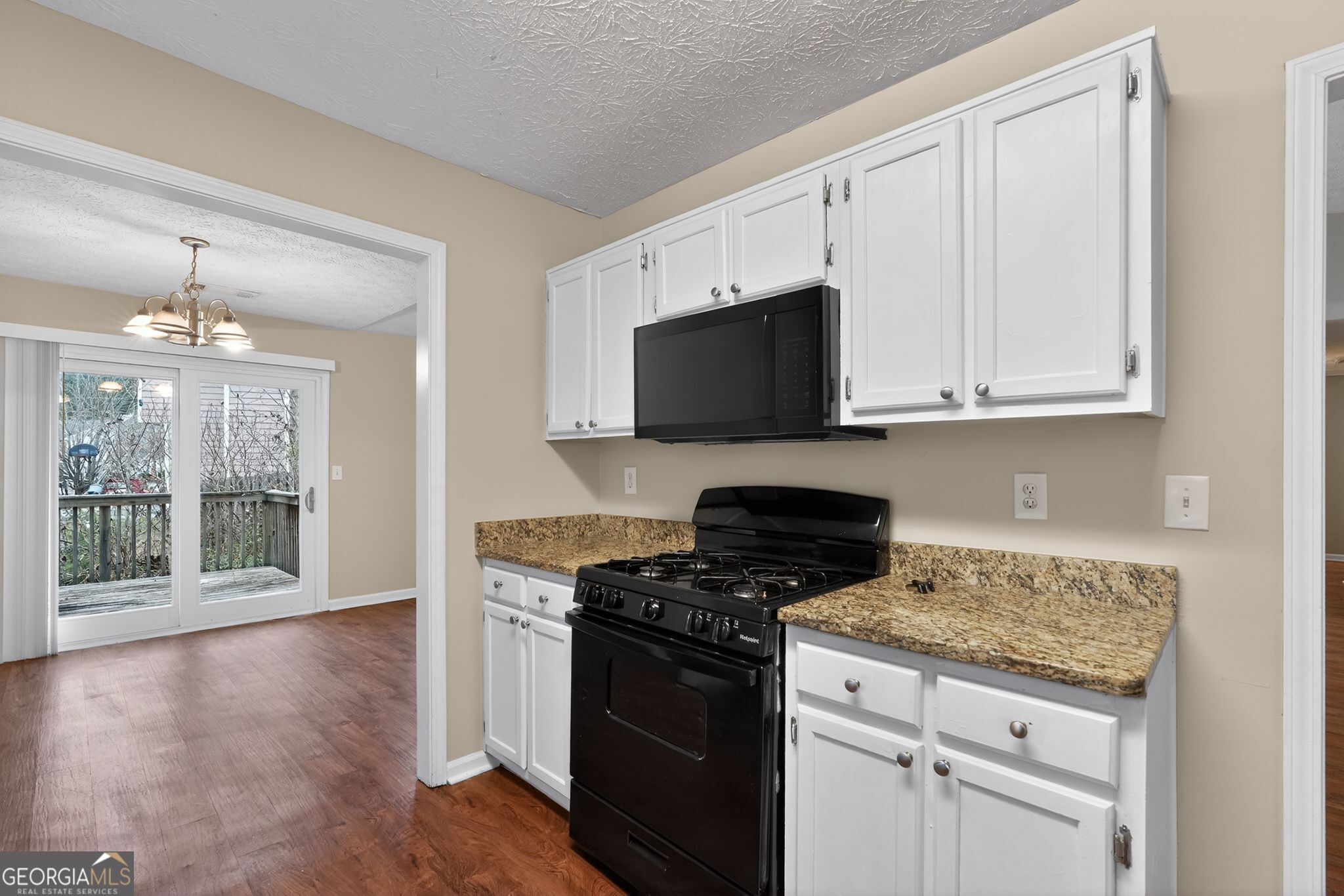 205 Whirlwind Court Atlanta, GA 30349 - Photo 11 of 32 a kitchen with stainless steel appliances granite countertop a stove and a microwave