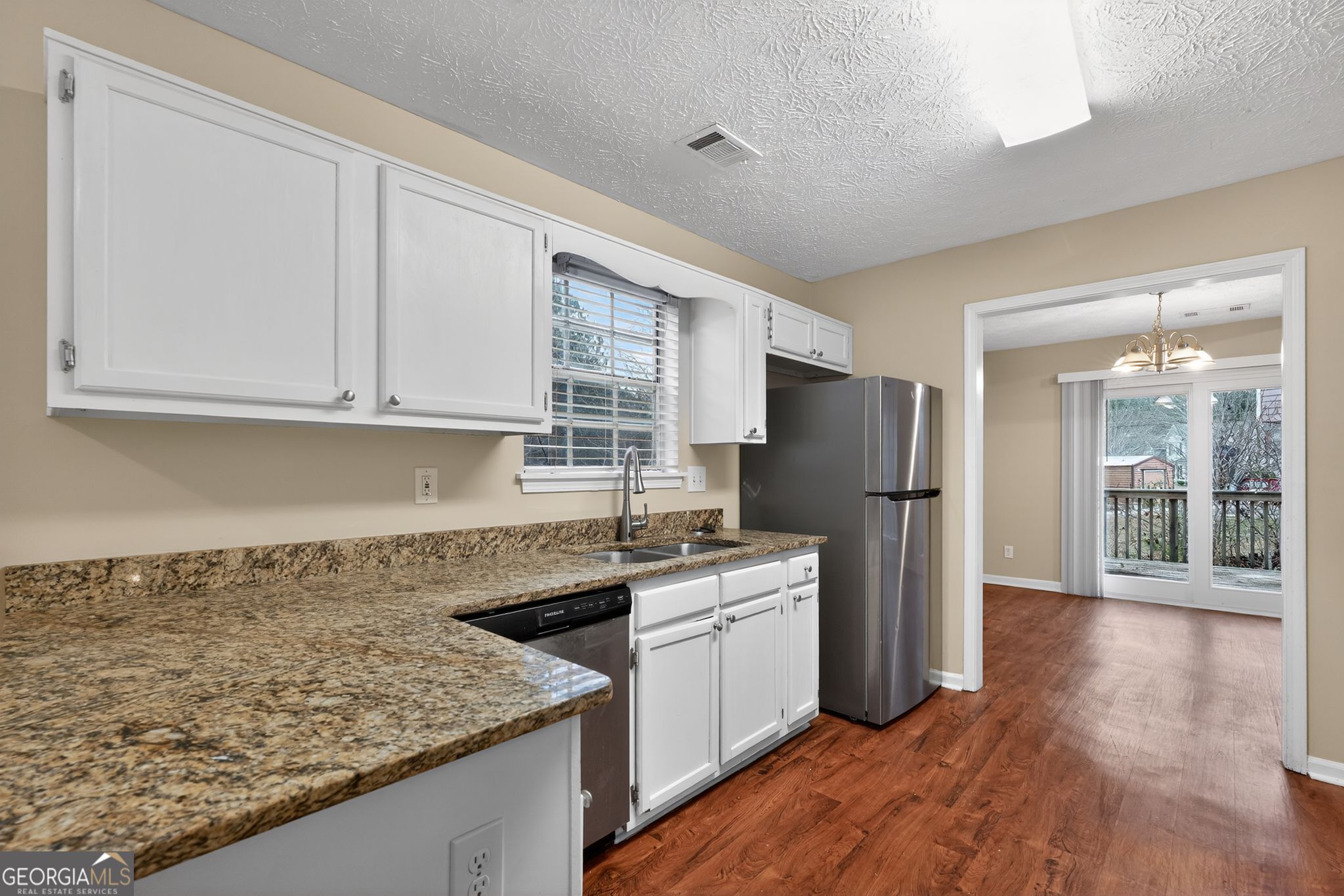 205 Whirlwind Court Atlanta, GA 30349 - Photo 13 of 32 a kitchen with a sink a refrigerator and cabinets