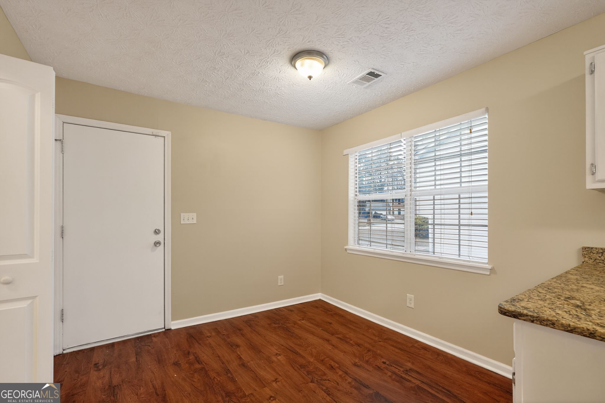 205 Whirlwind Court Atlanta, GA 30349 - Photo 14 of 32 a view of an empty room with wooden floor and a window